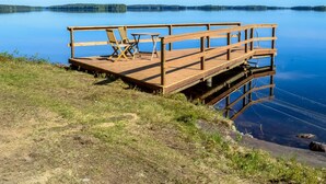 Een houten steiger met een tafel en stoelen die uitloopt in een rustig meer.
