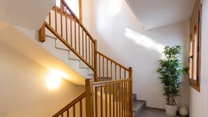 A staircase with wooden railings and a potted plant beside it.
