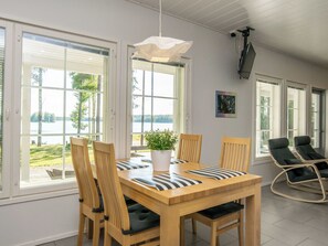 A dining area with a wooden table, chairs, and a potted plant.