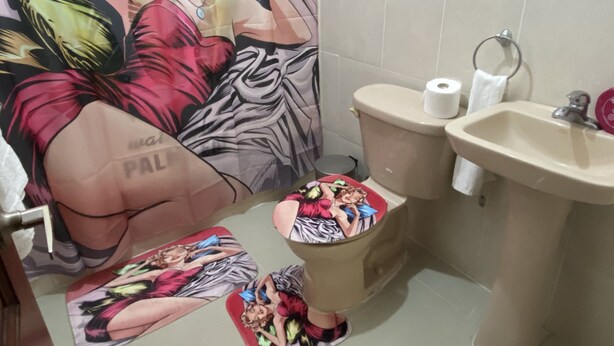 A bathroom with a toilet, sink, and a large mural on the wall. - 3DR Inviting 3-Bedroom Apt in Santo Domingo (Santo Domingo Norte)