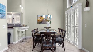 A dining area with a wooden table and chairs, a pendant light, and a painting on the wall. - Anchors Away - Three Bedroom House, Sleeps 12 (Osage Beach)