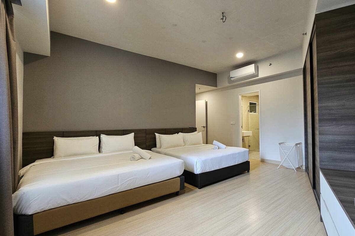 Une chambre d’hôtel moderne avec deux lits, une salle de bain et une vue sur la ville.