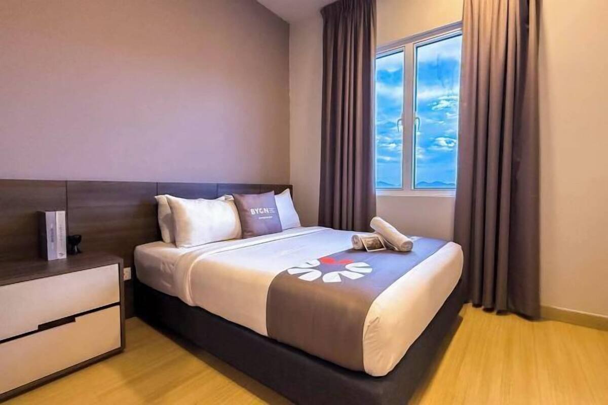 Une chambre d’hôtel avec un lit, une table de chevet, une fenêtre avec des rideaux et une vue sur le ciel.