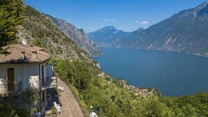 A mountain-side house with a balcony overlooking a lake and mountains. - Appartamento Secrel 9, Tremosine, Italy (Tremosine)