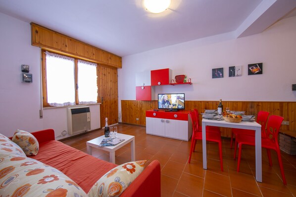 The living room with dinner table, TV and exit to the terrace