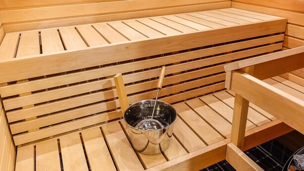 A sauna with wooden benches and a metal bucket. - Skistar 105 by Interhome (Kittilä)