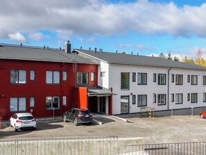 A two-story building with a red and white facade, a covered entrance, and a gravel driveway.