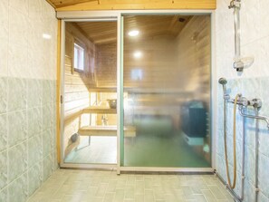 Ein Badezimmer mit Glastür, Dusche und Toilette.