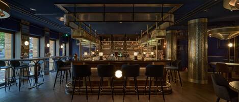 A bar area with a central bar, seating, and a decorative pillar.