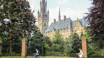 A historic building with a prominent clock tower and a gated entrance.