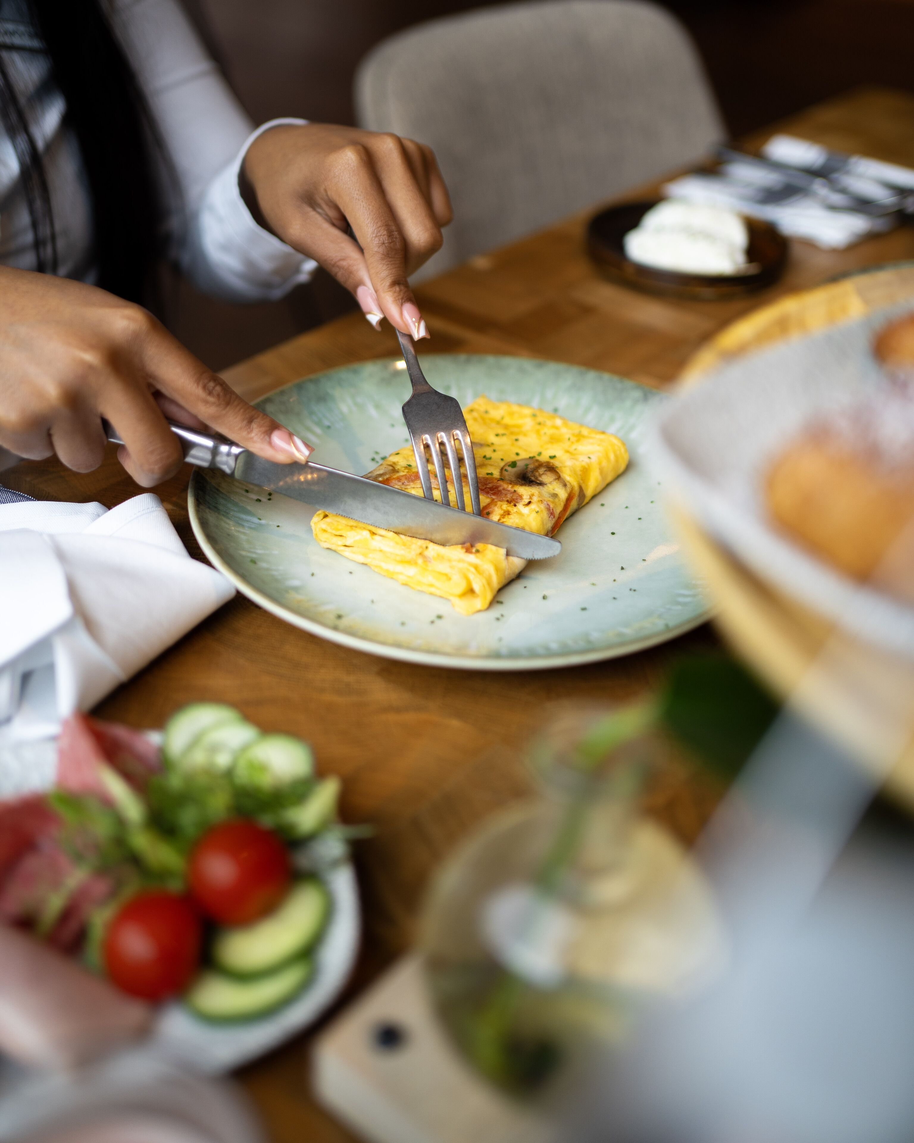 Una persona cortando una tortilla sobre un plato.