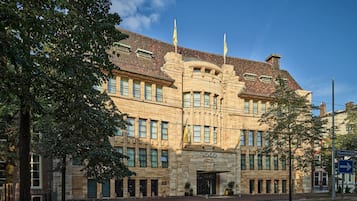 A historic building with a stone facade, multiple windows, and a prominent entrance.