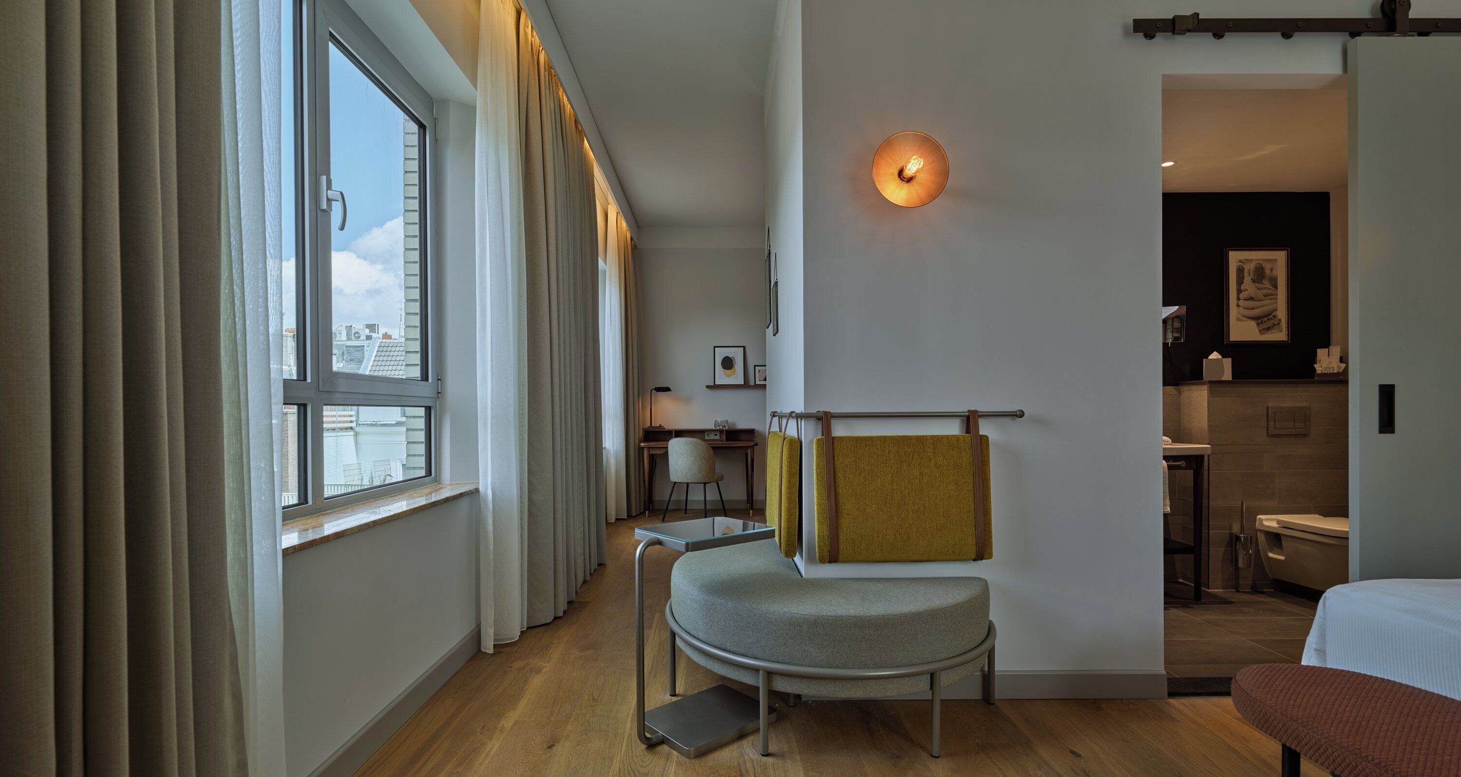 Una habitación de hotel con escritorio, silla y cama.