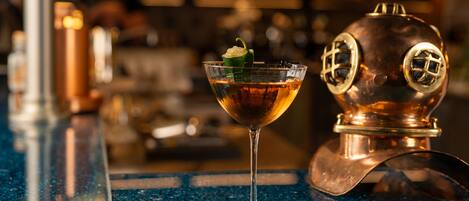 A bar setting with a cocktail glass and a copper distillation still.