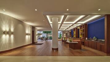 A spacious lobby with wooden flooring, a reception desk, and a blue accent wall.