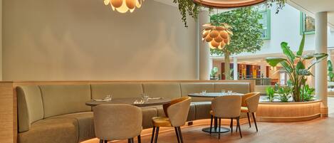 A modern interior with a seating area, wooden flooring, and hanging plants.