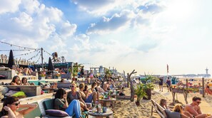 A beachside setting with outdoor seating and a view of the sea. - voco The Hague by IHG (The Hague)