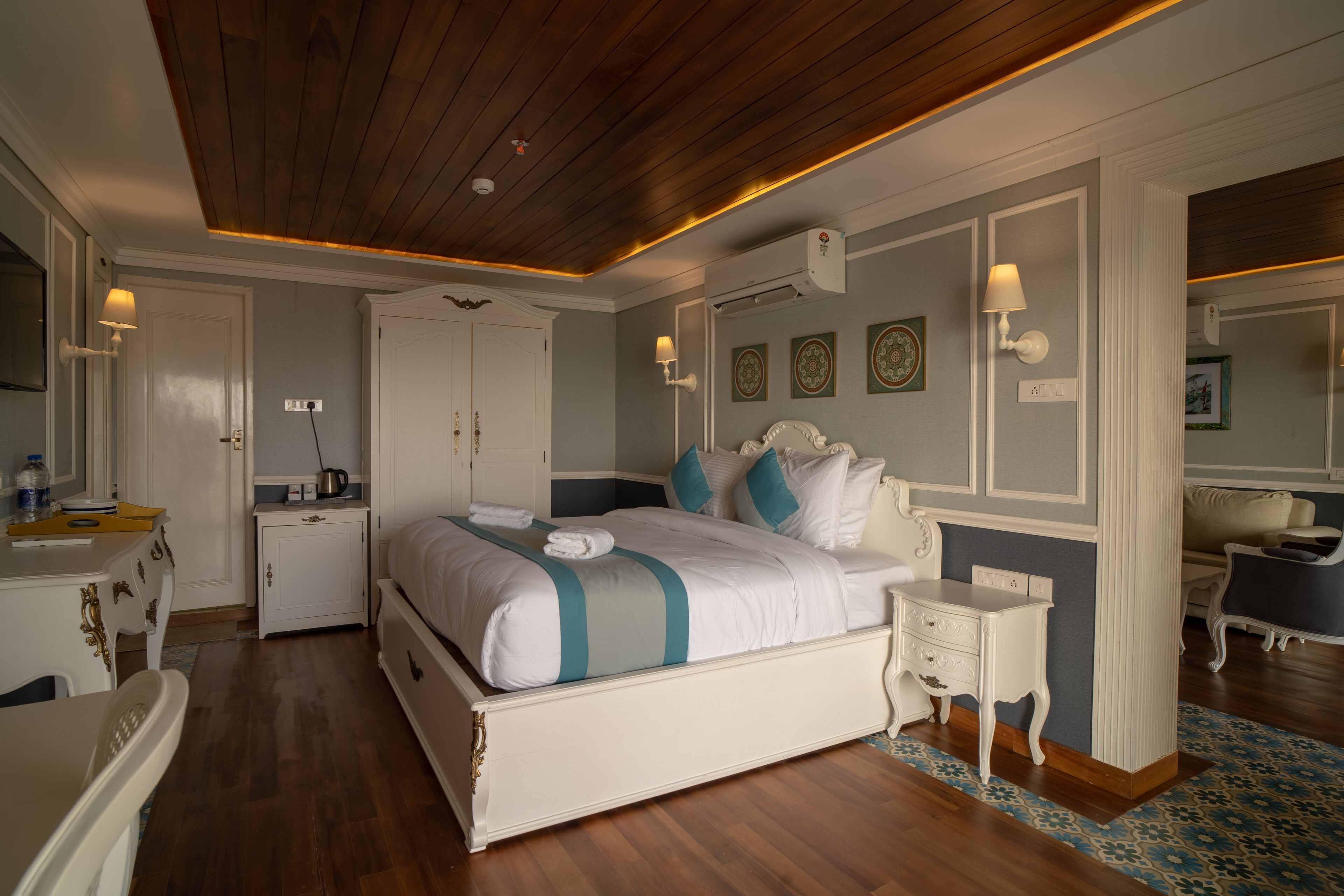 A bedroom with a large bed, bedside tables, a dresser, and a mirror.