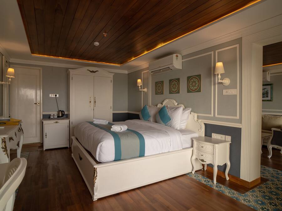 A bedroom with a large bed, bedside tables, a dresser, and a mirror.