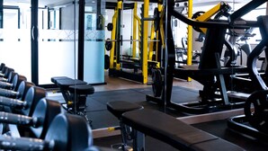 A gym with various exercise equipment, including dumbbells, benches, and weight machines. - GLOW Pattaya (Pattaya)