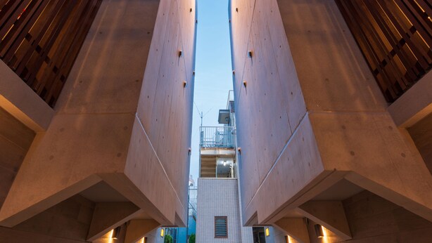 A modern building with a symmetrical facade, a central staircase, and a clear sky above. - Luana Shibuya (Tokyo)