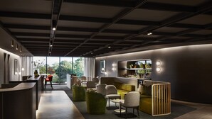 Un interior moderno con recepción, zona de estar y bar.