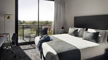 Una habitación de hotel moderna con una cama grande, un escritorio y una silla.
