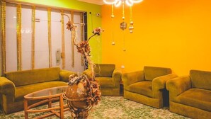 A room with a green sofa set, a wooden coffee table, and a decorative vase. - Dahab Plaza Hotel (Dahab)