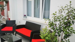 A patio with wicker furniture and a potted plant. - QueenSuite (Živogošće)