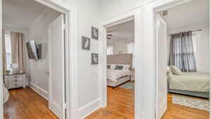 Ein Schlafzimmer mit einem Bett, einem Nachttisch und einem an der Wand befestigten Fernseher.
