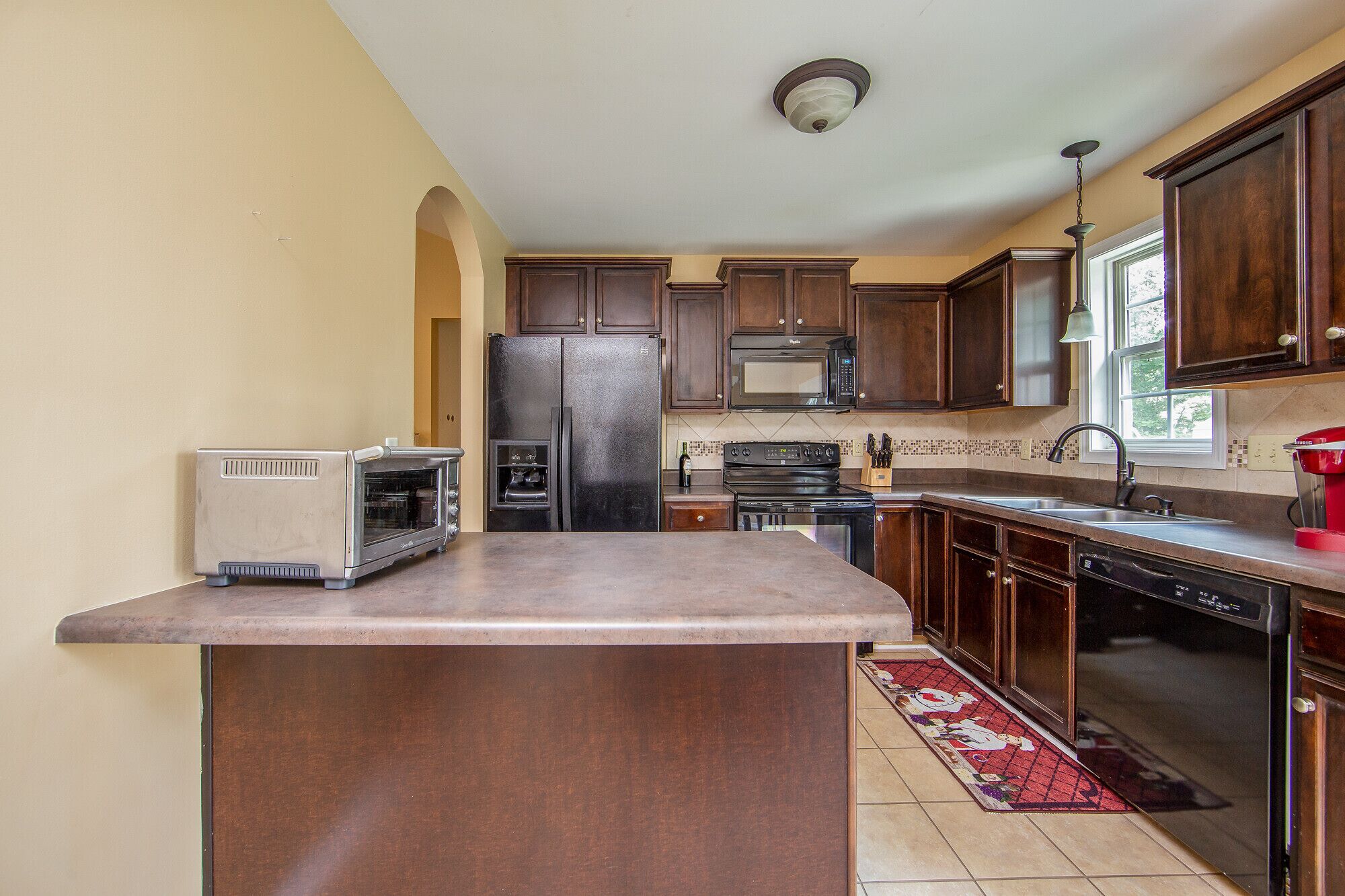 A kitchen with a built-in oven, microwave, stove, and refrigerator.