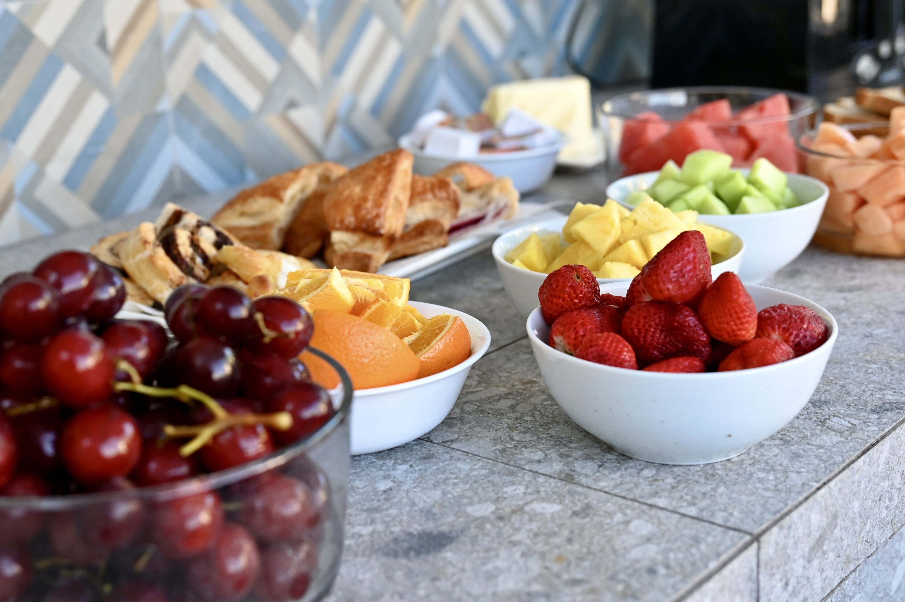Una mesa con diversas frutas y pasteles.