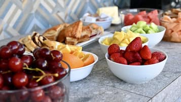 Una mesa con diversas frutas y pasteles.