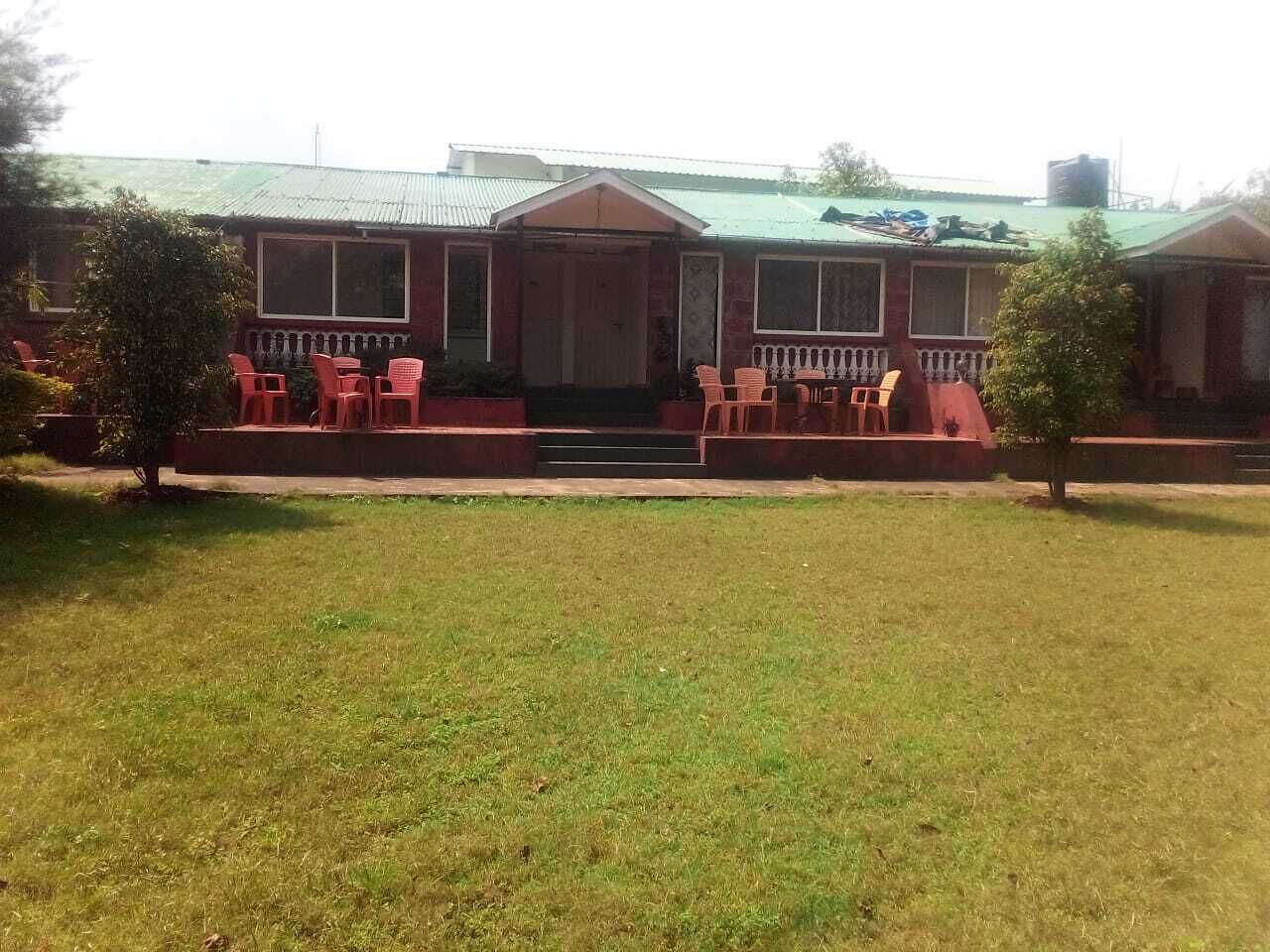 A building with a front porch, steps leading to the entrance, and a small lawn area in front.