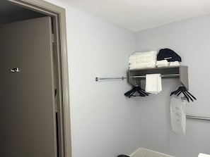 Un baño con un perchero, una toalla colgada y una puerta.