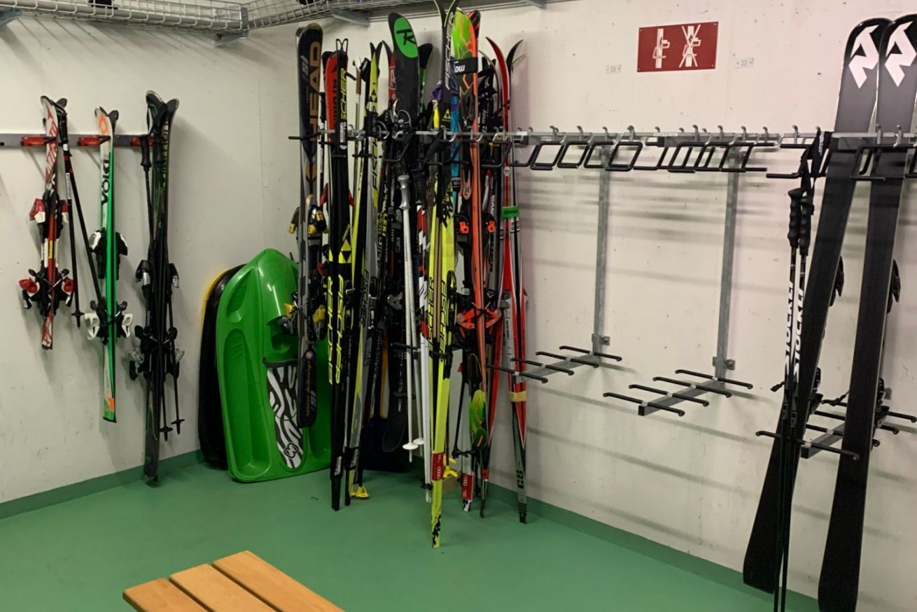 A ski storage room with multiple skis and ski poles.