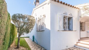 A white building with stone flooring, a tree, and a potted plant. - Magnificent villa between sea and forest with private pool and free wifi. (L'Escala)