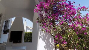 A white building with a pink flowering tree in an arched doorway. - Magnificent villa between sea and forest with private pool and free wifi. (L'Escala)