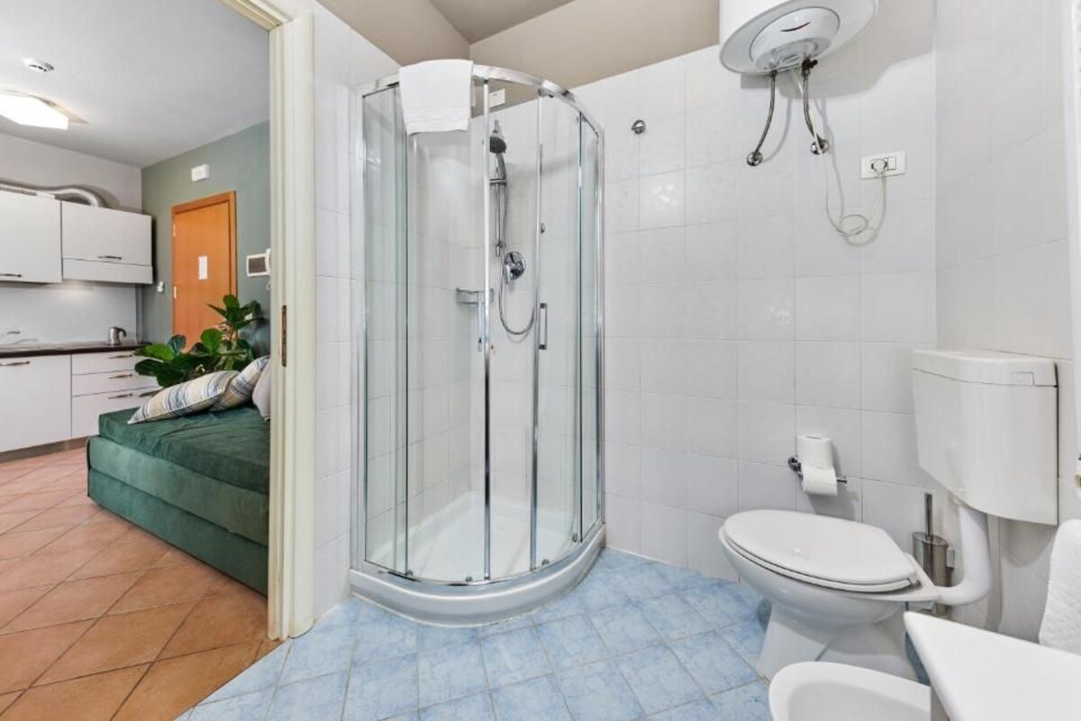 Un baño moderno con ducha de mampara de vidrio, inodoro y lavamanos.