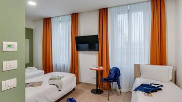 Una habitación de hotel con dos camas, un televisor, una mesita y una silla.