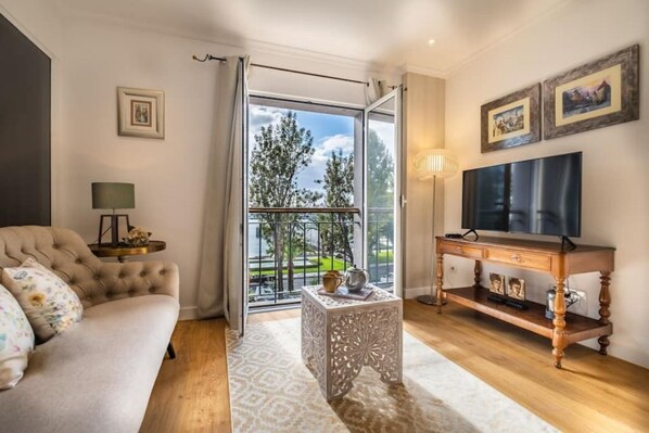 A living room with a sofa, a TV, a side table, and a decorative console table.