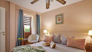 Une chambre d’hôtel avec un lit, une chaise, une table et une fenêtre avec des rideaux.