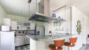 A modern kitchen with a marble countertop, stainless steel appliances, and a bar area with stools. - ❤️Luxury Villa with pool. NEW❤️ (pietrasanta)