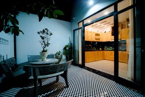 A modern kitchen with wooden cabinets and a tiled floor. - Hoian Royal Villa (Da Nang)