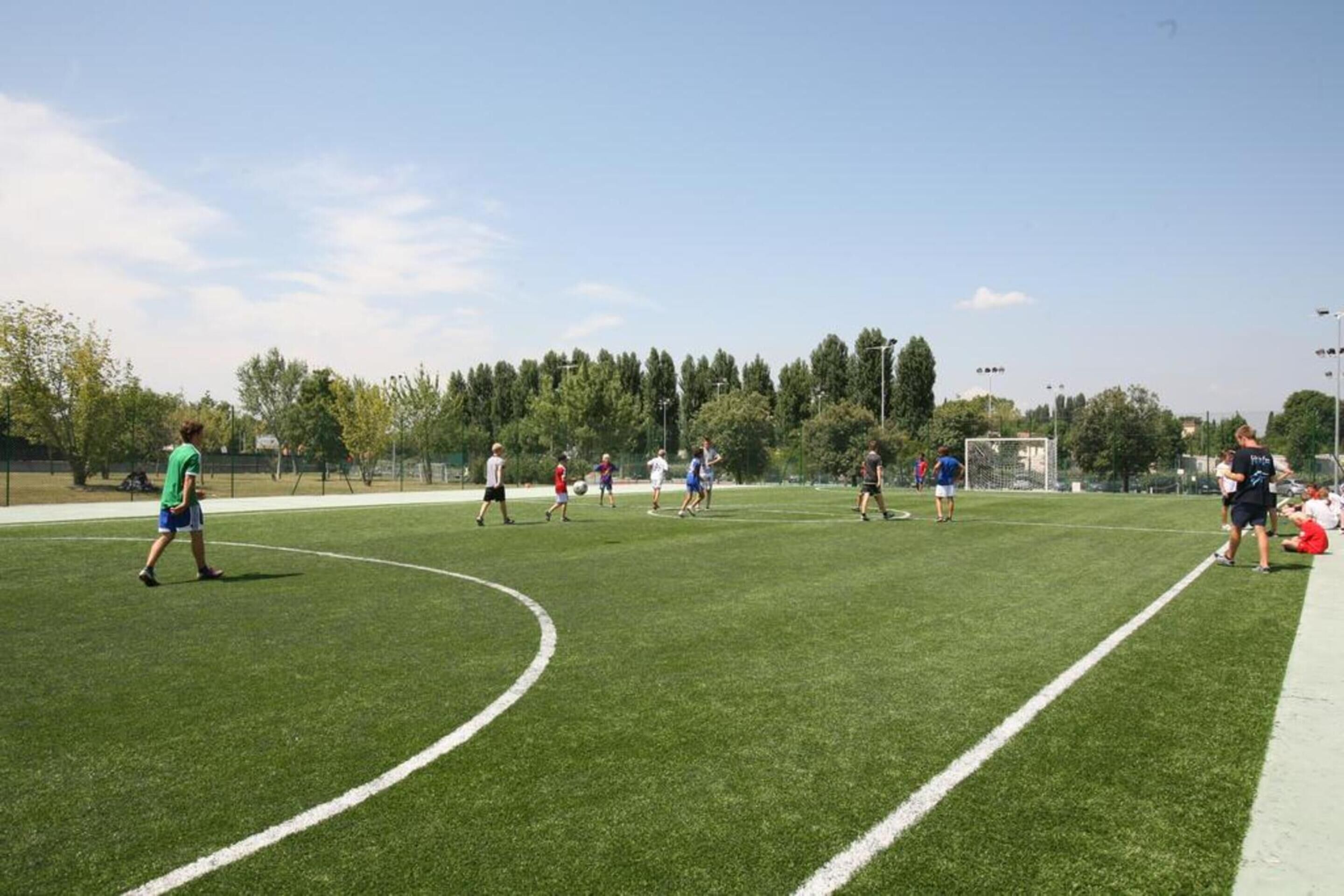 Un campo de fútbol con jugadores y espectadores.