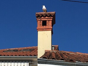 Un edificio con techo de tejas rojas y una chimenea.