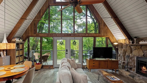 Un loft spazioso con soffitto alto, ampie finestre, un caminetto e un'accogliente area salotto.