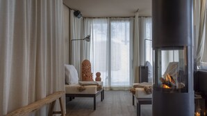 Una sala de estar acogedora con chimenea, un banco y un sofá.