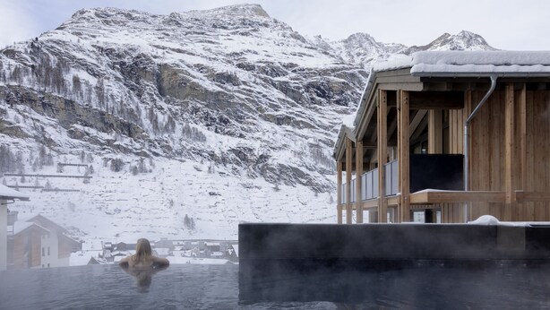 Un edificio de madera con vista a montañas nevadas.