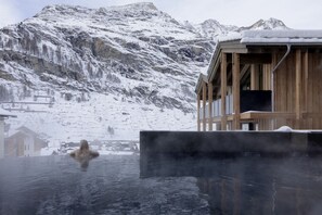 A wooden building with a view of snow-covered mountains.